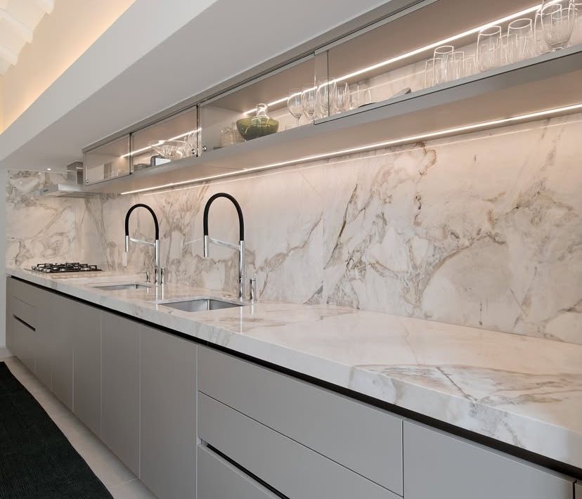 Tủ bếp cánh acrylic sáng bóng nâng đỡ mặt đá bàn bếp vân mây trắng 