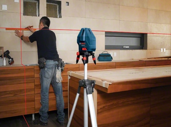 Ảnh chụp kỹ sư thiết kế đang sử dụng máy đo khoảng cách bằng laser chuyên dụng để đo đạc