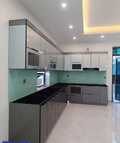 Cận cảnh chi tiết thùng tủ bếp inox 304 kết hợp mặt đá thạch anh màu vàng nhạt và ánh đèn LED vàng tạo cảm giác ấm cúng